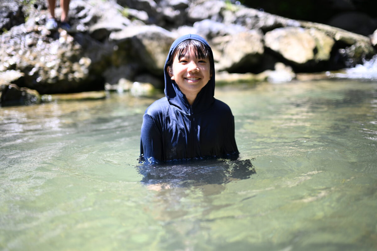女の子が川に使って笑顔の写真