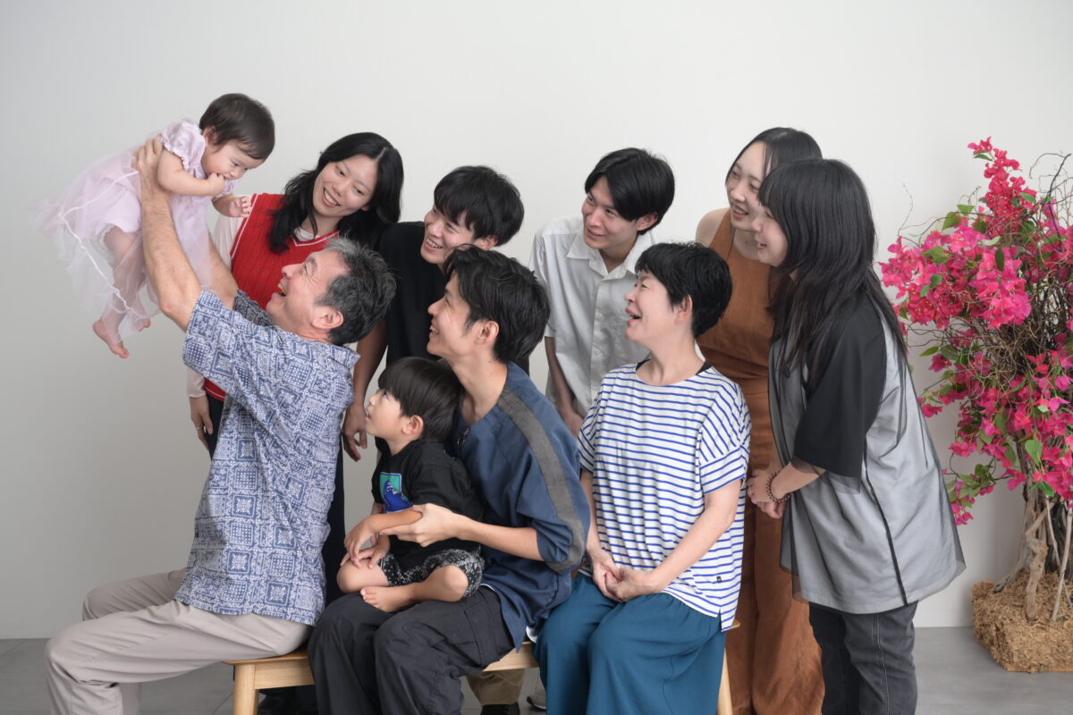 お孫さんを祖父が高いたいしている家族写真